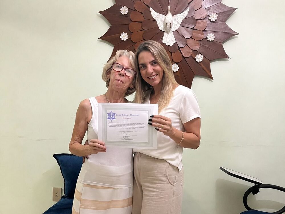 Delma entregando certificado de Reiki Mestrado a uma aluna